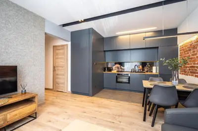 a living room with a dining room table and a kitchen at RentPlanet - Apartament Prusa in Kraków