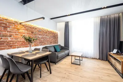 a living room with a brick wall and a table and chairs at RentPlanet - Apartament Prusa in Kraków
