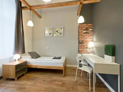a bedroom with a bed and a desk and a table at 2-bedroom apartment - 51 Dietla Street in Kraków