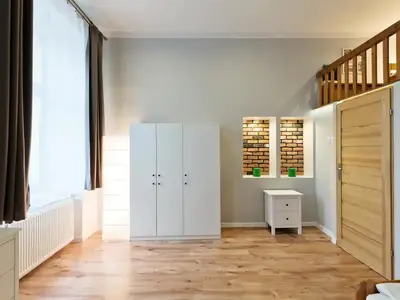 a bedroom with white cabinets and a wooden floor at 2-bedroom apartment - 51 Dietla Street in Kraków
