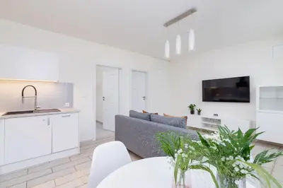a white living room with a couch and a table at One bedroom apartment in the centre - Sarego 16 in Kraków