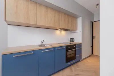 a kitchen with blue cabinets and a sink at Apartment with balcony Kalwaryjska 34 street in Kraków