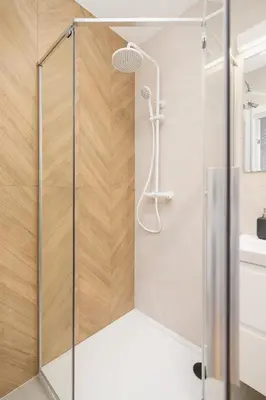 a shower with a glass door in a bathroom at Apartment with balcony Kalwaryjska 34 street in Kraków