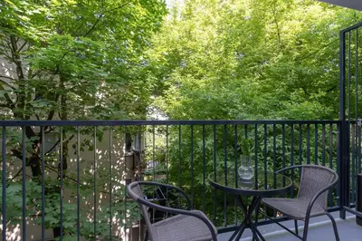 a table and chairs on a balcony with trees at Apartment with balcony Kalwaryjska 34 street in Kraków