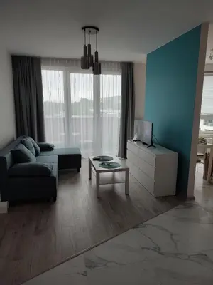 a living room with a couch and a table at Apartamenty przy Mogilskiej z miejscem postojowym in Kraków