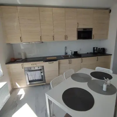 a kitchen with a table and chairs and a kitchen with cabinets at Apartamenty przy Mogilskiej z miejscem postojowym in Kraków