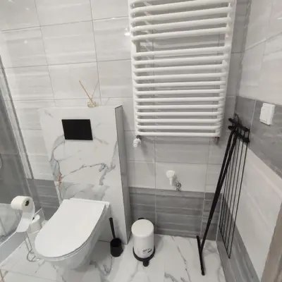 a white bathroom with a toilet and a window at Apartamenty przy Mogilskiej z miejscem postojowym in Kraków