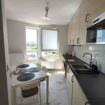 a kitchen with a sink and a counter top at Apartamenty przy Mogilskiej z miejscem postojowym in Kraków