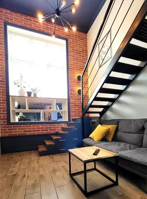 a living room with a couch and a staircase at Przystań na Kazimierzu in Kraków
