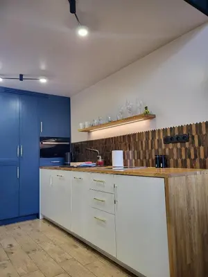 a kitchen with white counters and blue cabinets at Przystań na Kazimierzu in Kraków