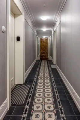 a corridor with a tile floor in a hallway at Wawel View Stylish Apartment - Kościuszki 22 in Kraków