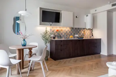 a kitchen with a table and a tv on the wall at Wawel View Stylish Apartment - Kościuszki 22 in Kraków