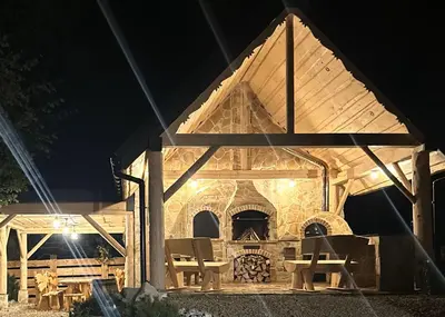 a pavilion with a stone fireplace at night at Bale na Skale Chata & SPA-Zawoja in Skawica