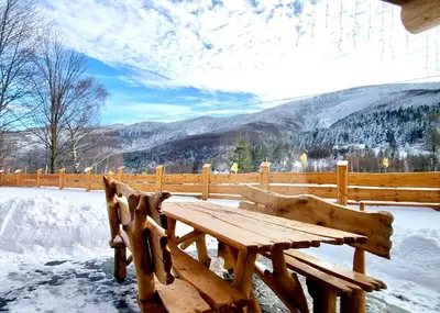 a wooden bench sitting on top of a snow covered deck at Bale na Skale Chata & SPA-Zawoja in Skawica