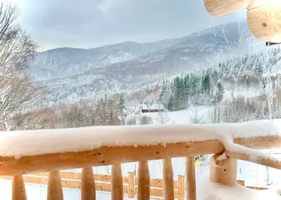 a snow covered balcony with a view of a mountain at Bale na Skale Chata & SPA-Zawoja in Skawica