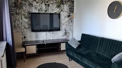 a living room with a couch and a flat screen tv at Green apartament 21 in Oświęcim