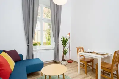 a living room with a blue couch and a table at Apartment with City View - Dietla 68 street in Kraków