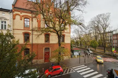 a red car parked in front of a brick building at Apartment with City View - Dietla 68 street in Kraków