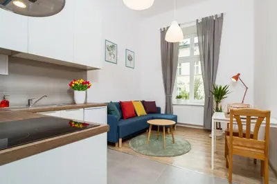 a kitchen and living room with a couch and a table at Apartment with City View - Dietla 68 street in Kraków