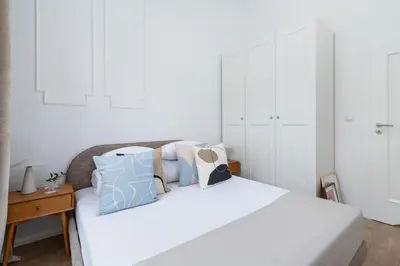 a white bed with a bunch of pillows on it at One Bedroom Apartment - Dietla 68 street in Kraków
