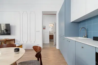a kitchen with blue walls and a table and chairs at One Bedroom Apartment - Dietla 68 street in Kraków