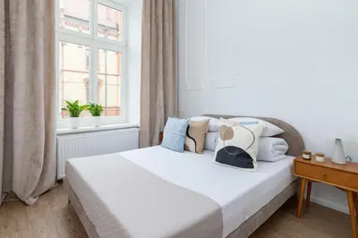 a bedroom with a white bed with pillows and a window at One Bedroom Apartment - Dietla 68 street in Kraków