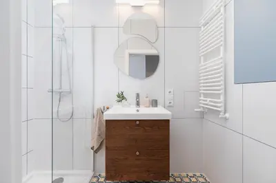 a white bathroom with a sink and a mirror at One Bedroom Apartment - Dietla 68 street in Kraków