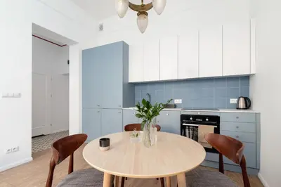 a kitchen with a wooden table and chairs at One Bedroom Apartment - Dietla 68 street in Kraków