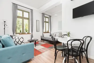a living room with a blue couch and a table at Studio Apartment - Dietla 109 street in Kraków