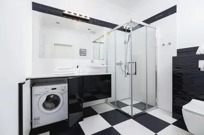 a bathroom with a sink and a washing machine at Studio Apartment - Dietla 109 street in Kraków
