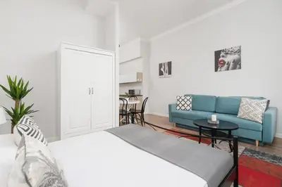 a living room with a bed and a blue couch at Studio Apartment - Dietla 109 street in Kraków