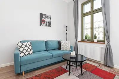 a living room with a blue couch and a table at Studio Apartment - Dietla 109 street in Kraków