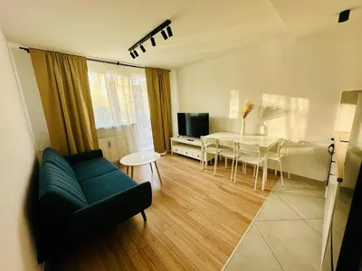 a living room with a couch and a dining room at Apartament Powstańców 19 in Oświęcim