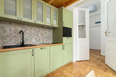 a kitchen with green cabinets and a sink at Apartment with balcony - Dietla 109 street in Kraków