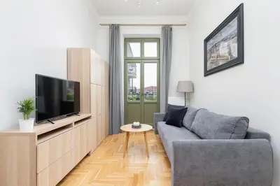 a living room with a couch and a flat screen tv at Apartment with balcony - Dietla 109 street in Kraków