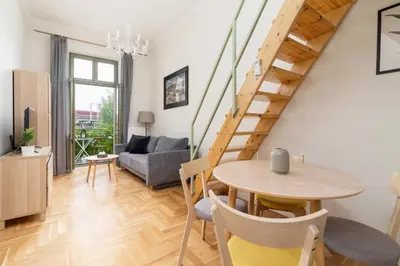 a living room with a table and a staircase at Apartment with balcony - Dietla 109 street in Kraków