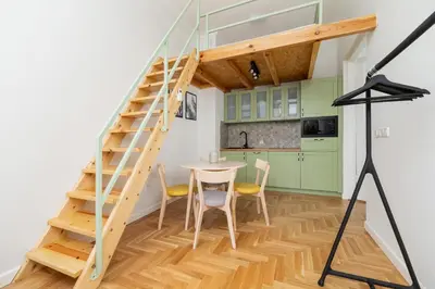 a staircase in a kitchen with a table and chairs at Apartment with balcony - Dietla 109 street in Kraków