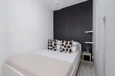 a bedroom with a bed with pillows on it at One Bedroom Apartment with a Balcony - Dietla 109 street in Kraków