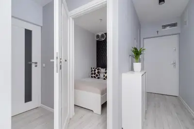 a white room with a bed and a door at One Bedroom Apartment with a Balcony - Dietla 109 street in Kraków