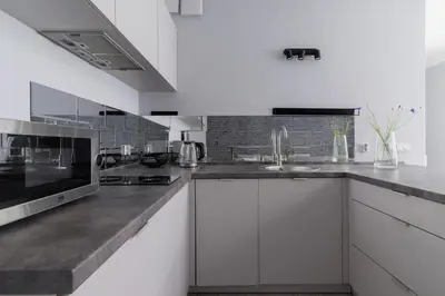 a kitchen with white cabinets and a sink at One Bedroom Apartment with a Balcony - Dietla 109 street in Kraków