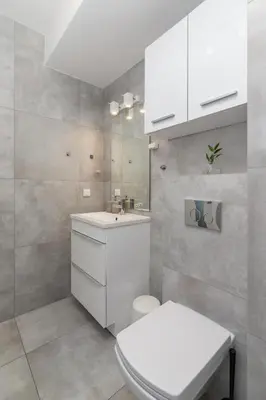 a white bathroom with a toilet and a sink at One Bedroom Apartment with a Balcony - Dietla 109 street in Kraków
