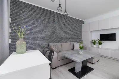 a living room with a couch and a brick wall at One Bedroom Apartment with a Balcony - Dietla 109 street in Kraków