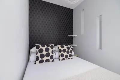 a bedroom with a white bed with polka dot pillows at One Bedroom Apartment with a Balcony - Dietla 109 street in Kraków