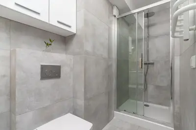 a bathroom with a shower with a glass door at One Bedroom Apartment with a Balcony - Dietla 109 street in Kraków