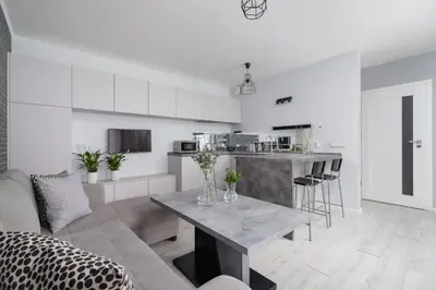 a kitchen and living room with a table at One Bedroom Apartment with a Balcony - Dietla 109 street in Kraków