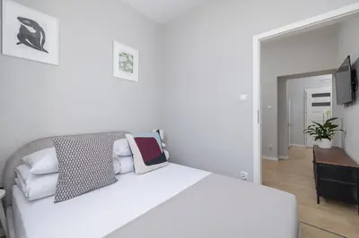 a white bedroom with a large white bed with pillows at 3-bedroom apartment - Old Town- Blich 9 in Kraków