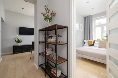 a living room with a book shelf and a bed at 3-bedroom apartment - Old Town- Blich 9 in Kraków