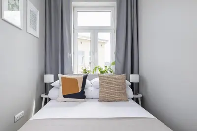 a bedroom with a bed with pillows and a window at 3-bedroom apartment - Old Town- Blich 9 in Kraków