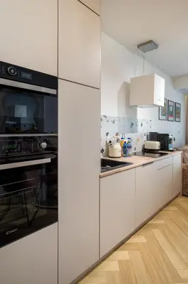 a kitchen with white cabinets and a stove top oven at Charming Apartment in a green area- free parking in Kraków