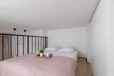 a bedroom with a large bed with two plants on it at Studio z Klimatyzacją na Krakowskim Kazimierzu by Noclegi Renters in Kraków